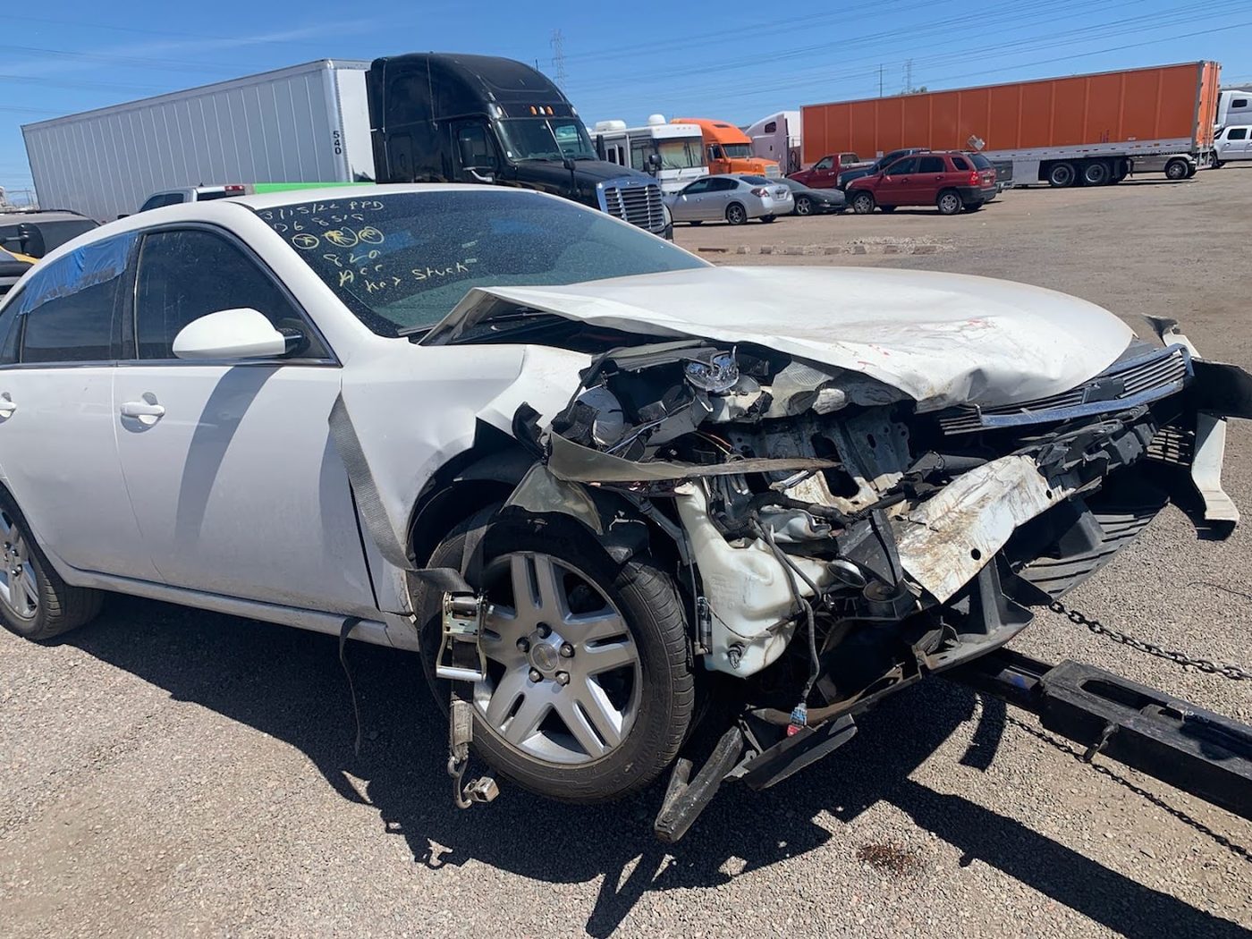 Wrecked white sedan with front-end collision damage bought for cash in Phoenix, Arizona